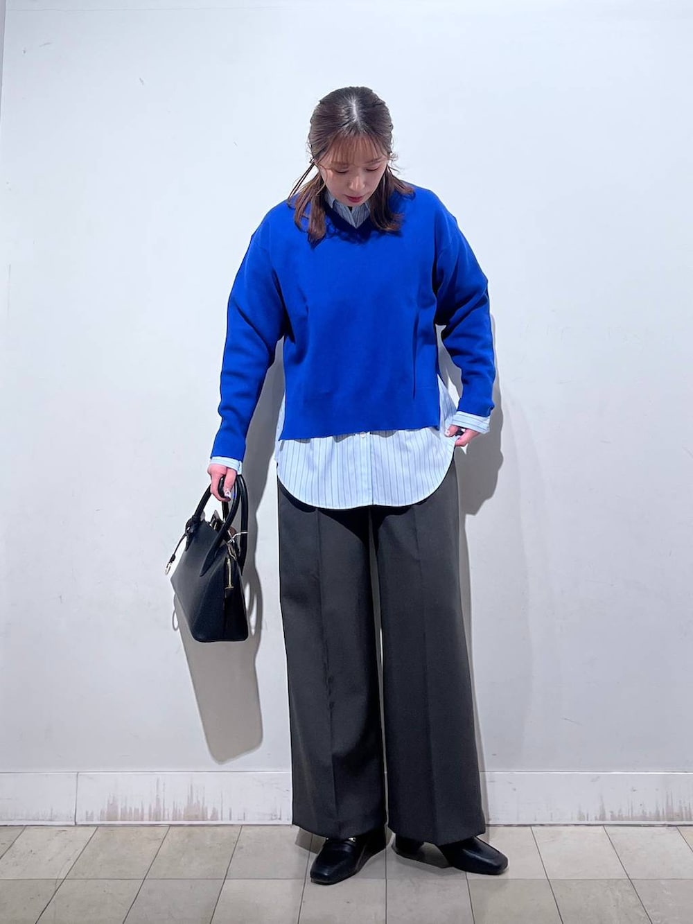 ブラック系のローファー、ブラック系のショルダーバッグ、ブルー系のシャツ/ブラウスを着用したレディースの冬コーディネートの6枚目の写真