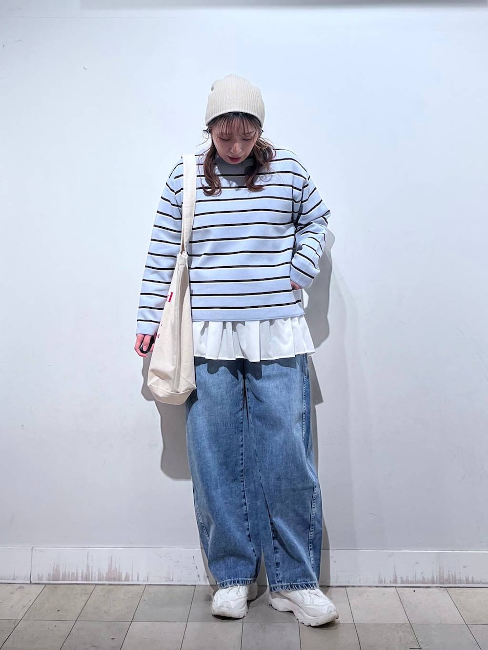 ホワイト系のTシャツ/カットソー、ホワイト系のトートバッグ、ブルー系のニット/セーターを着用したレディースの冬コーディネートの8枚目の写真