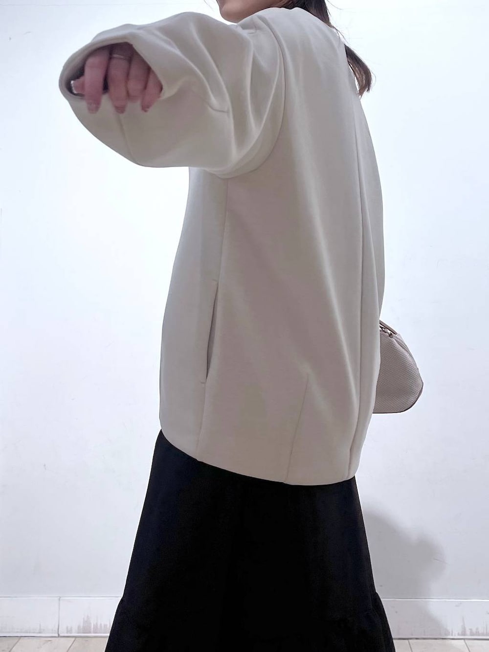 ホワイト系のショルダーバッグ、ブラック系のローファー、ホワイト系のブルゾンを着用したレディースの春コーディネートの4枚目の写真