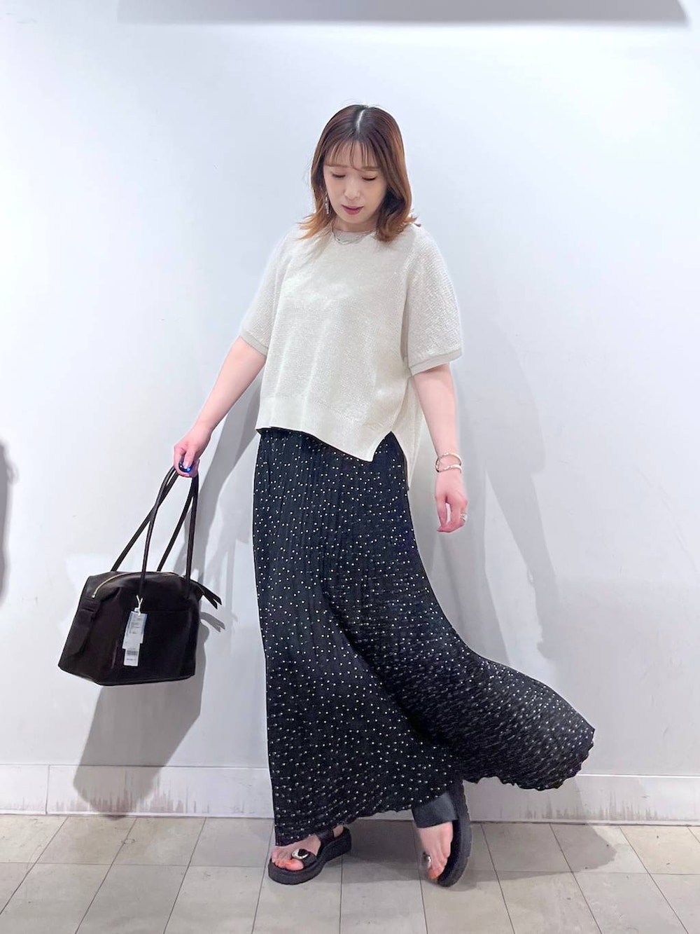 その他のスカート、ブラウン系のボストンバッグ、ホワイト系のタンクトップを着用したレディースの夏コーディネートの2枚目の写真
