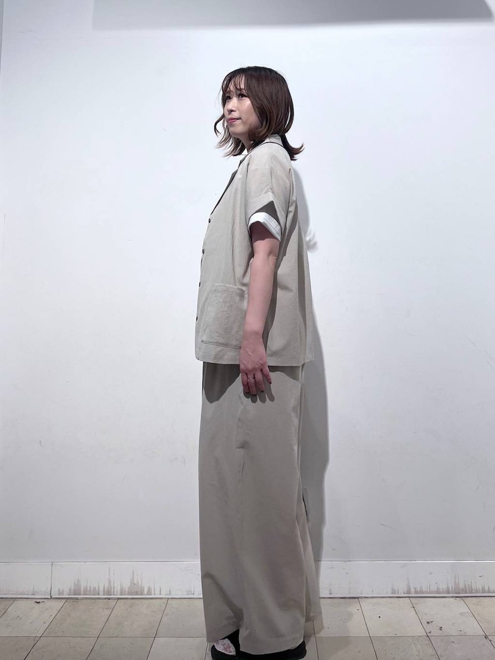 ブラウン系のショルダーバッグ、ベージュ系のその他パンツ、ホワイト系のTシャツ/カットソーを着用したレディースの夏コーディネートの2枚目の写真
