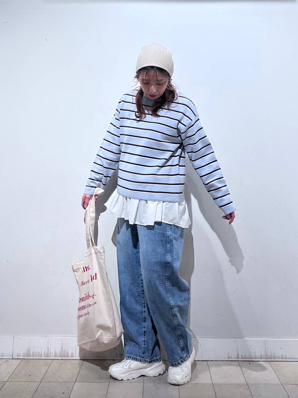 ホワイト系のTシャツ/カットソー、ホワイト系のトートバッグ、ブルー系のニット/セーターを着用したレディースの冬コーディネートの3枚目の写真