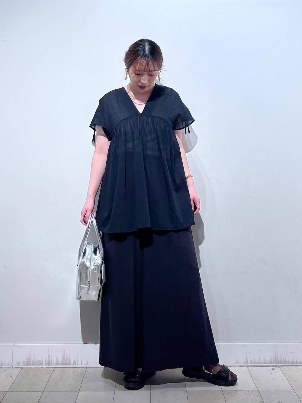 グレー系のボストンバッグ、ブラック系のサンダル、ブラック系のシャツ/ブラウスを着用したレディースの夏コーディネートの7枚目の写真