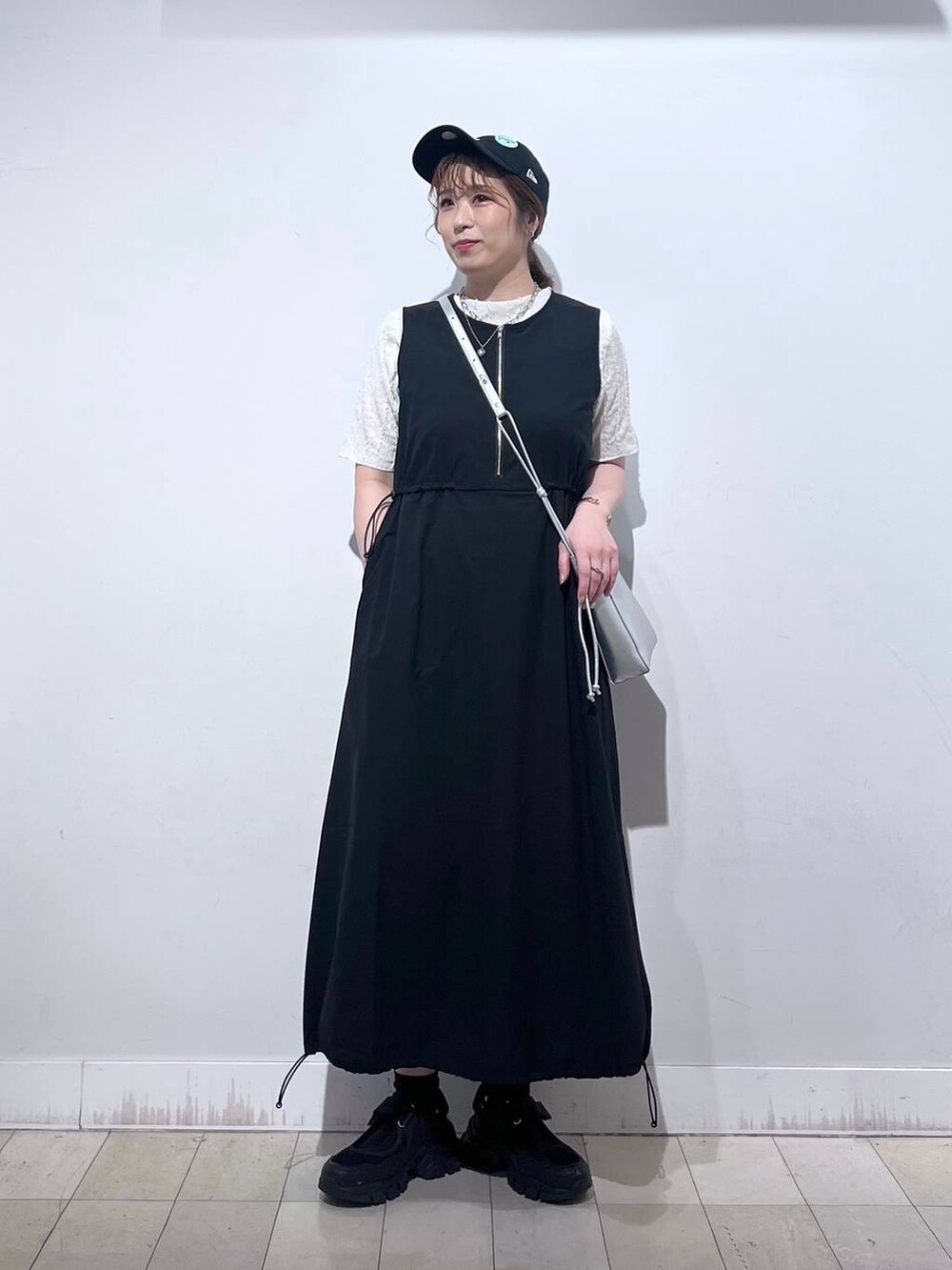 ブラック系のスニーカー、シルバー系のショルダーバッグ、ベージュ系のTシャツ/カットソーを着用したレディースの夏コーディネートの7枚目の写真