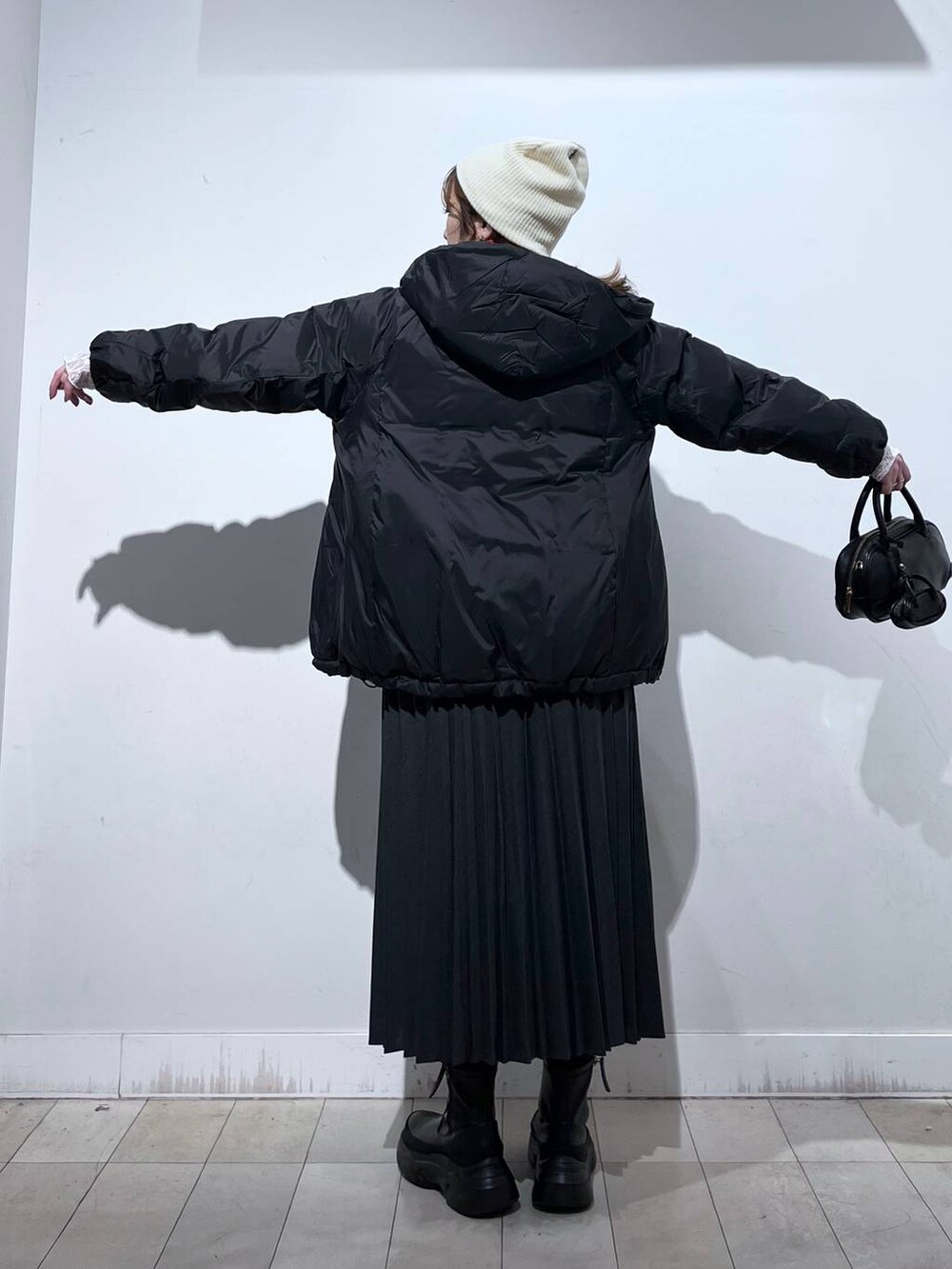 ブラック系のダウンジャケット/コート、ホワイト系のTシャツ/カットソー、レッド系のニット/セーターを着用したレディースの冬コーディネートの6枚目の写真