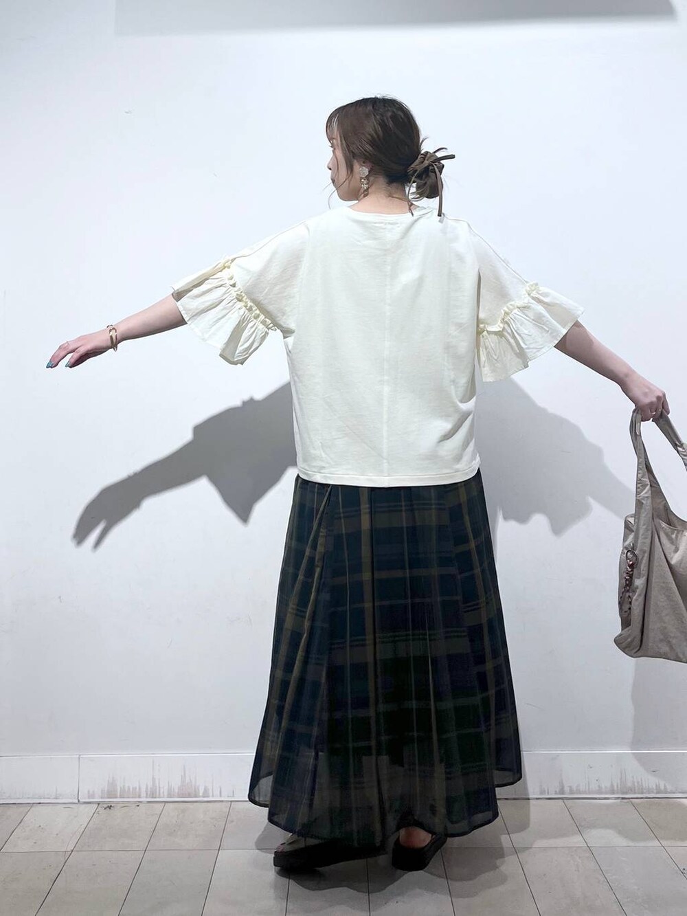 ホワイト系のタンクトップ、ベージュ系のトートバッグ、ベージュ系のサンダルを着用したレディースの秋コーディネートの8枚目の写真