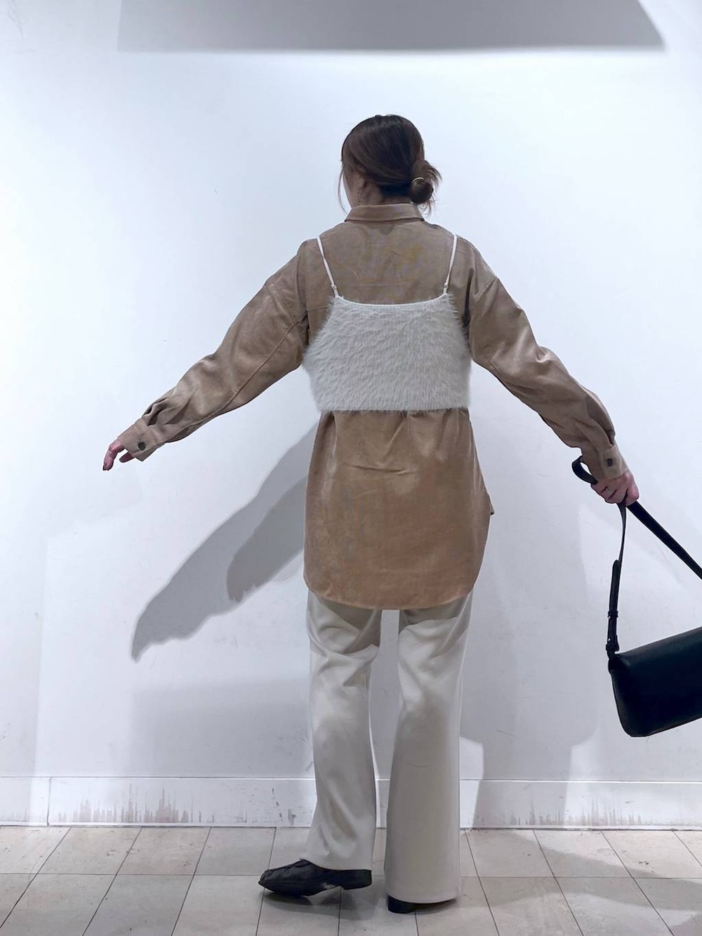 ベージュ系のその他パンツ、ホワイト系のベスト、ブラック系のショルダーバッグを着用したレディースの秋コーディネートの4枚目の写真