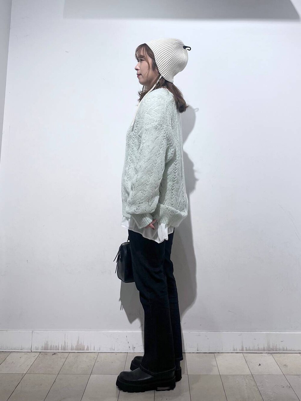 ブラック系のデニムパンツ、ホワイト系のTシャツ/カットソー、ブラック系のボストンバッグを着用したレディースの秋コーディネートの5枚目の写真