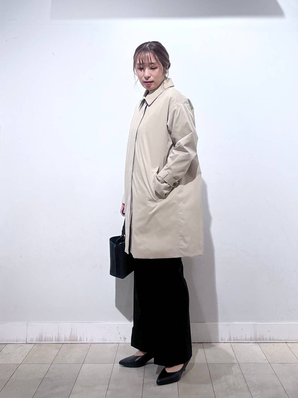 ブラック系のパンプス、ブルー系のセットアップ、ブラック系のショルダーバッグを着用したレディースの冬コーディネートの6枚目の写真