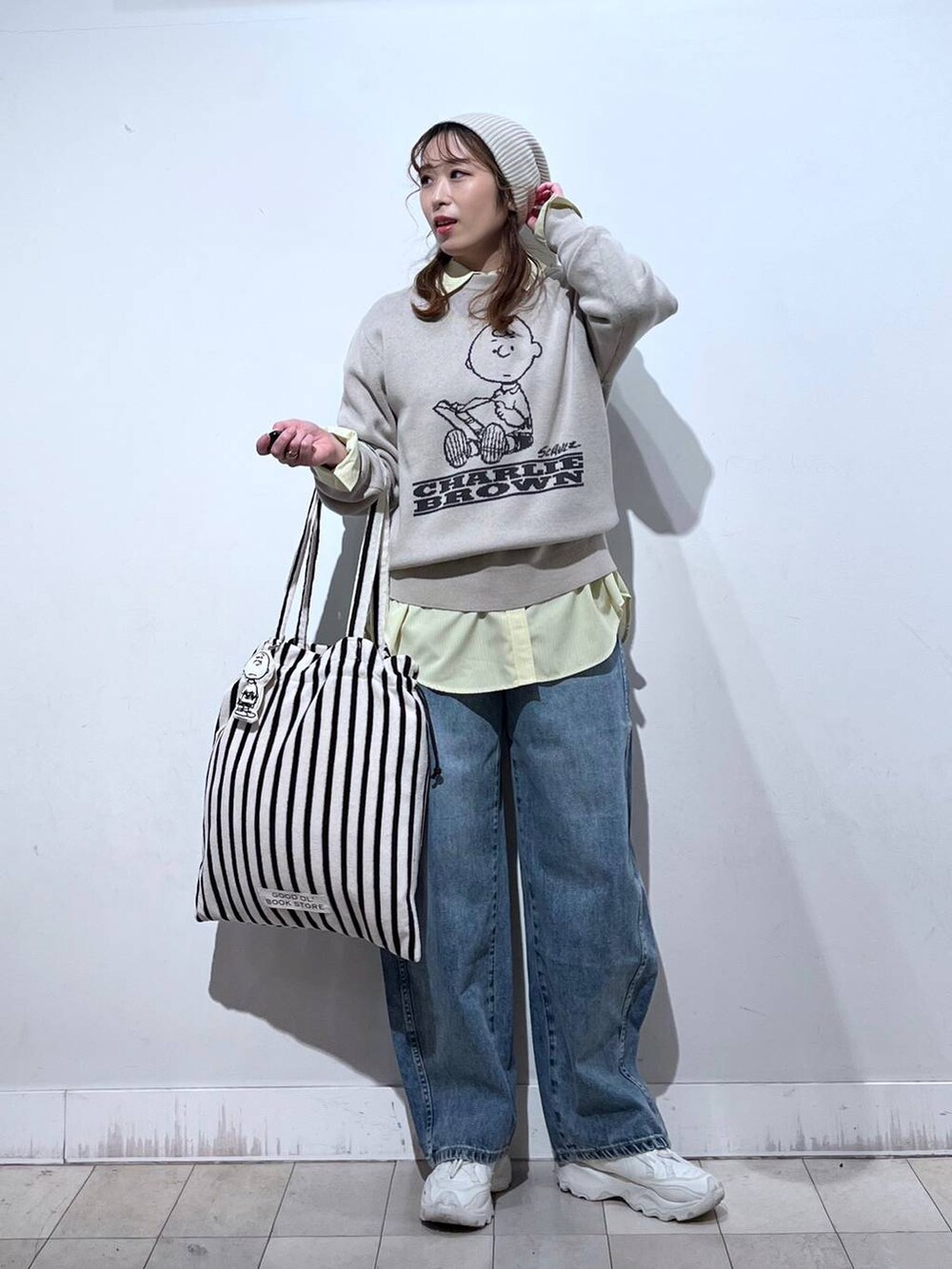 イエロー系のシャツ/ブラウス、ブルー系のデニムパンツ、ベージュ系のニット/セーターを着用したレディースの冬コーディネートの4枚目の写真