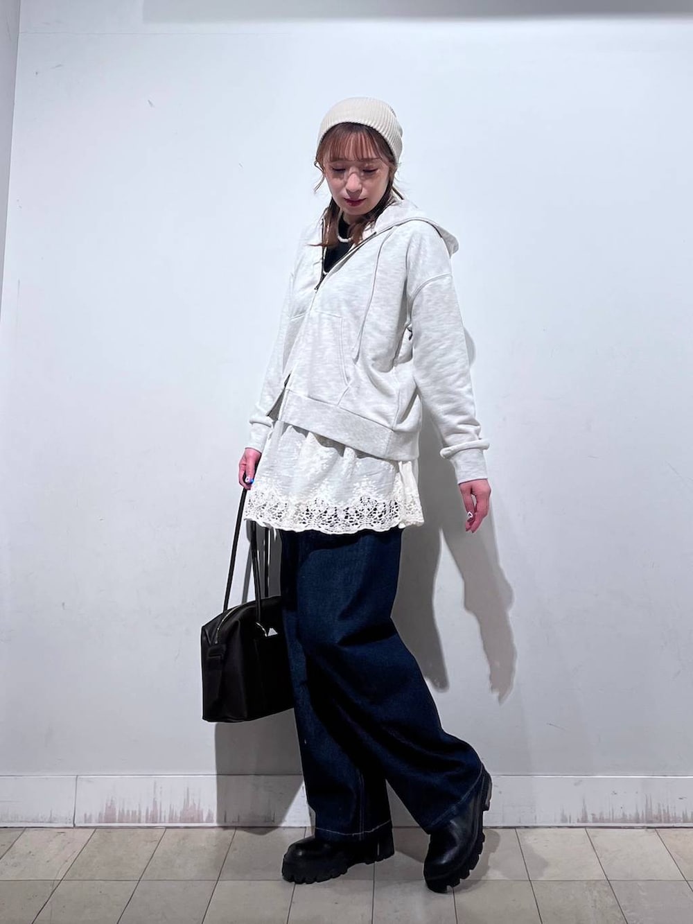 ブラウン系のボストンバッグ、ホワイト系のパーカー、ホワイト系のその他トップスを着用したレディースの冬コーディネートの2枚目の写真