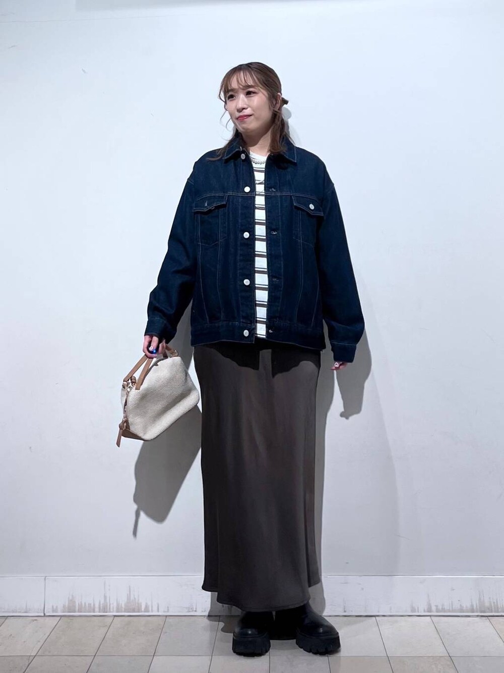 ホワイト系のショルダーバッグ、ブルー系のデニムジャケット、ブラウン系のスカートを着用したレディースの冬コーディネートの9枚目の写真