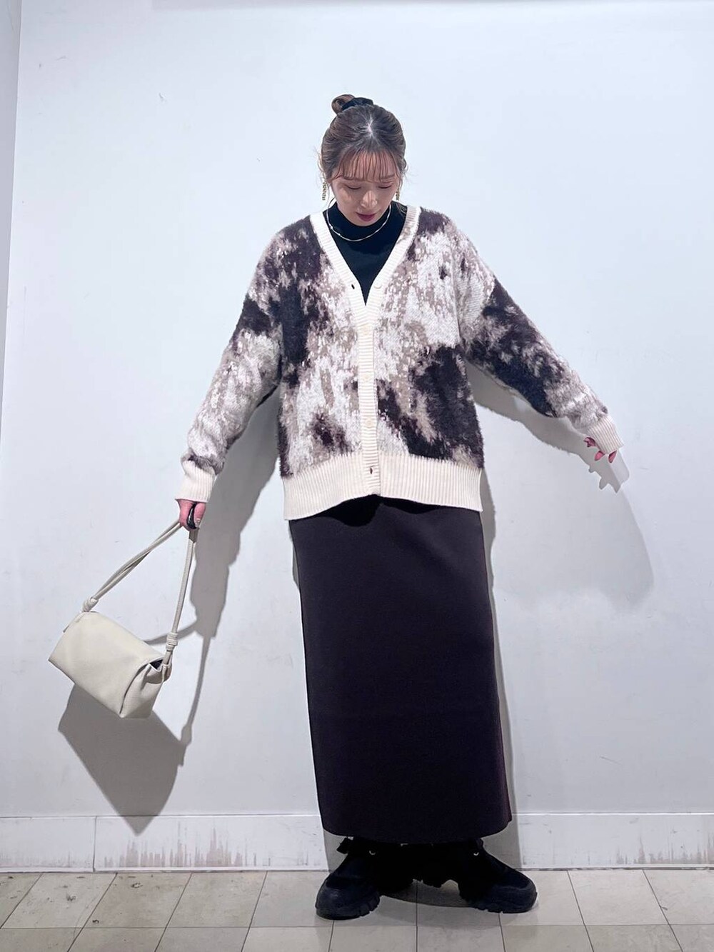 ブラック系のスニーカー、ブラック系のニット/セーター、ベージュ系のショルダーバッグを着用したレディースの秋コーディネートの8枚目の写真