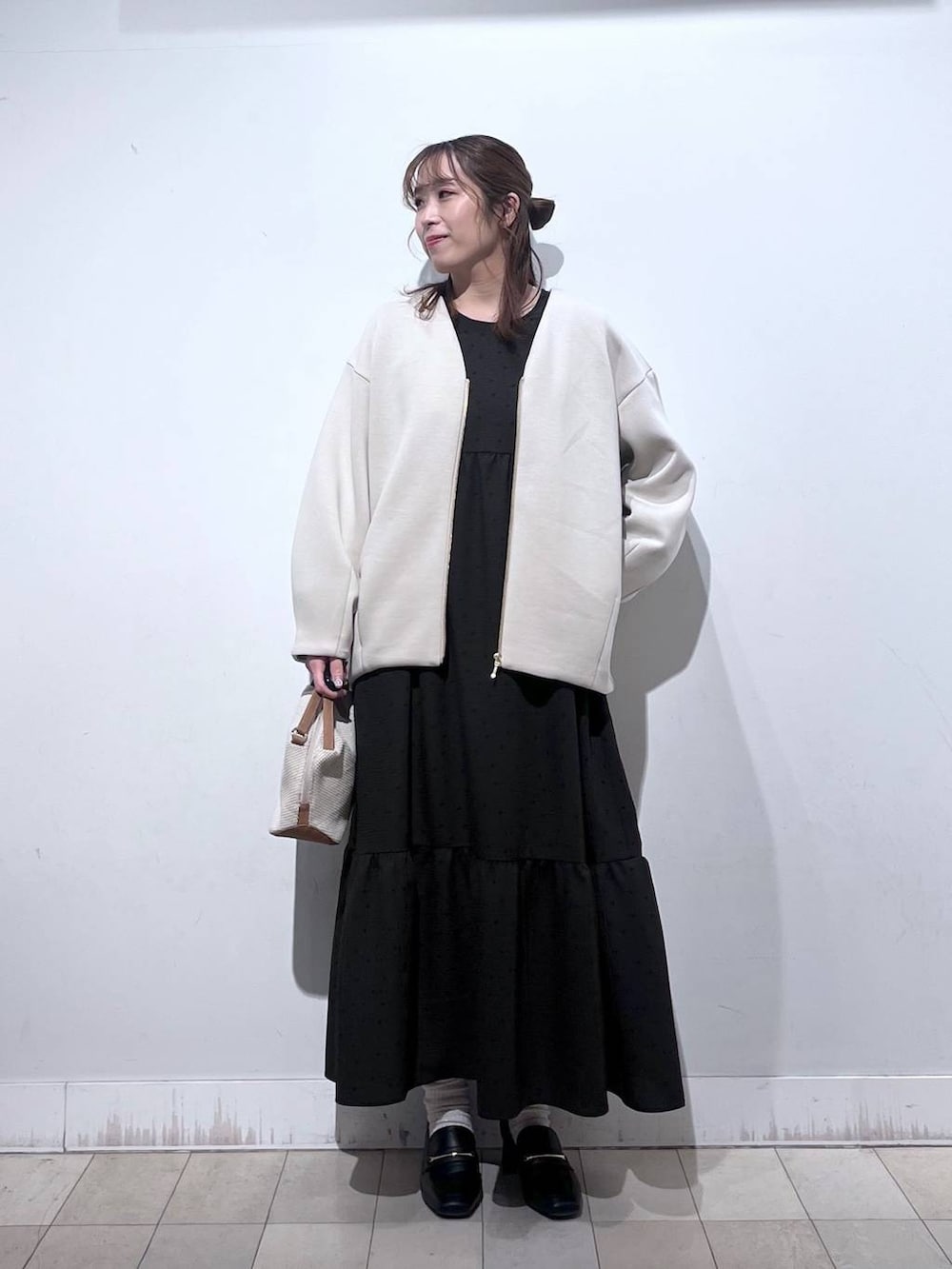 ホワイト系のショルダーバッグ、ブラック系のローファー、ホワイト系のブルゾンを着用したレディースの春コーディネートの6枚目の写真