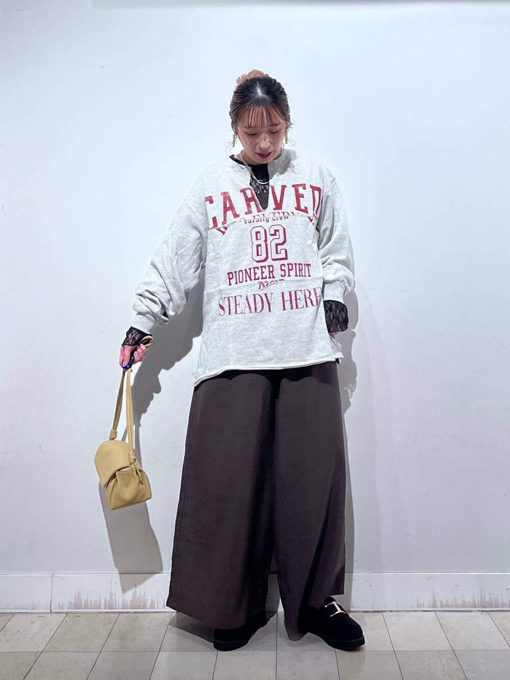 ブラック系のローファー、イエロー系のショルダーバッグ、ブラック系のTシャツ/カットソーを着用したレディースの秋コーディネートの7枚目の写真
