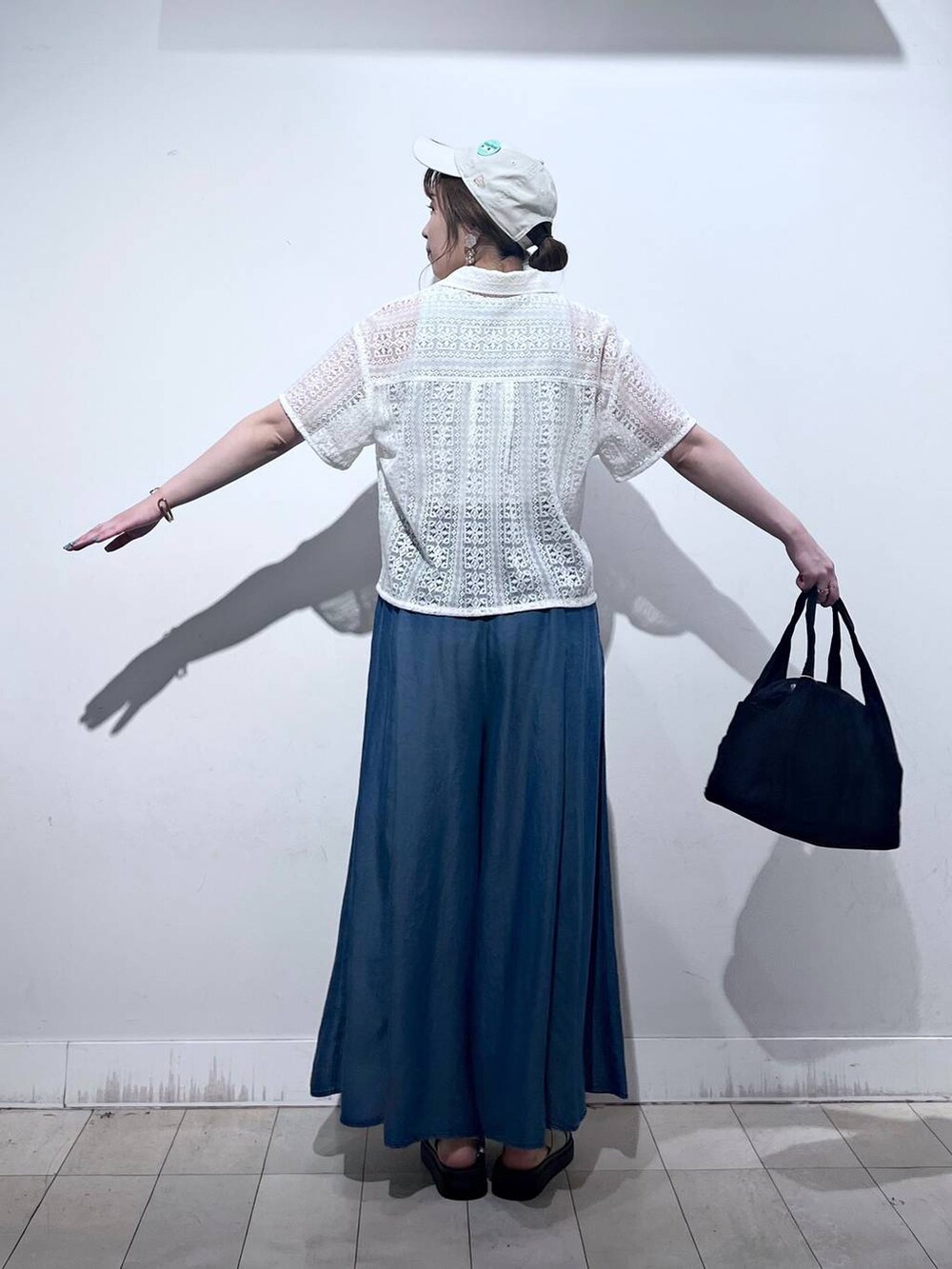 ブラック系のトートバッグ、ブルー系のその他パンツ、ベージュ系のサンダルを着用したレディースの夏コーディネートの8枚目の写真