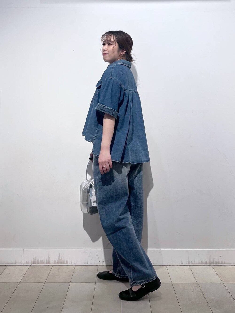 ブルー系のデニムパンツ、その他のパンプス、グレー系のボストンバッグを着用したレディースの春コーディネートの2枚目の写真