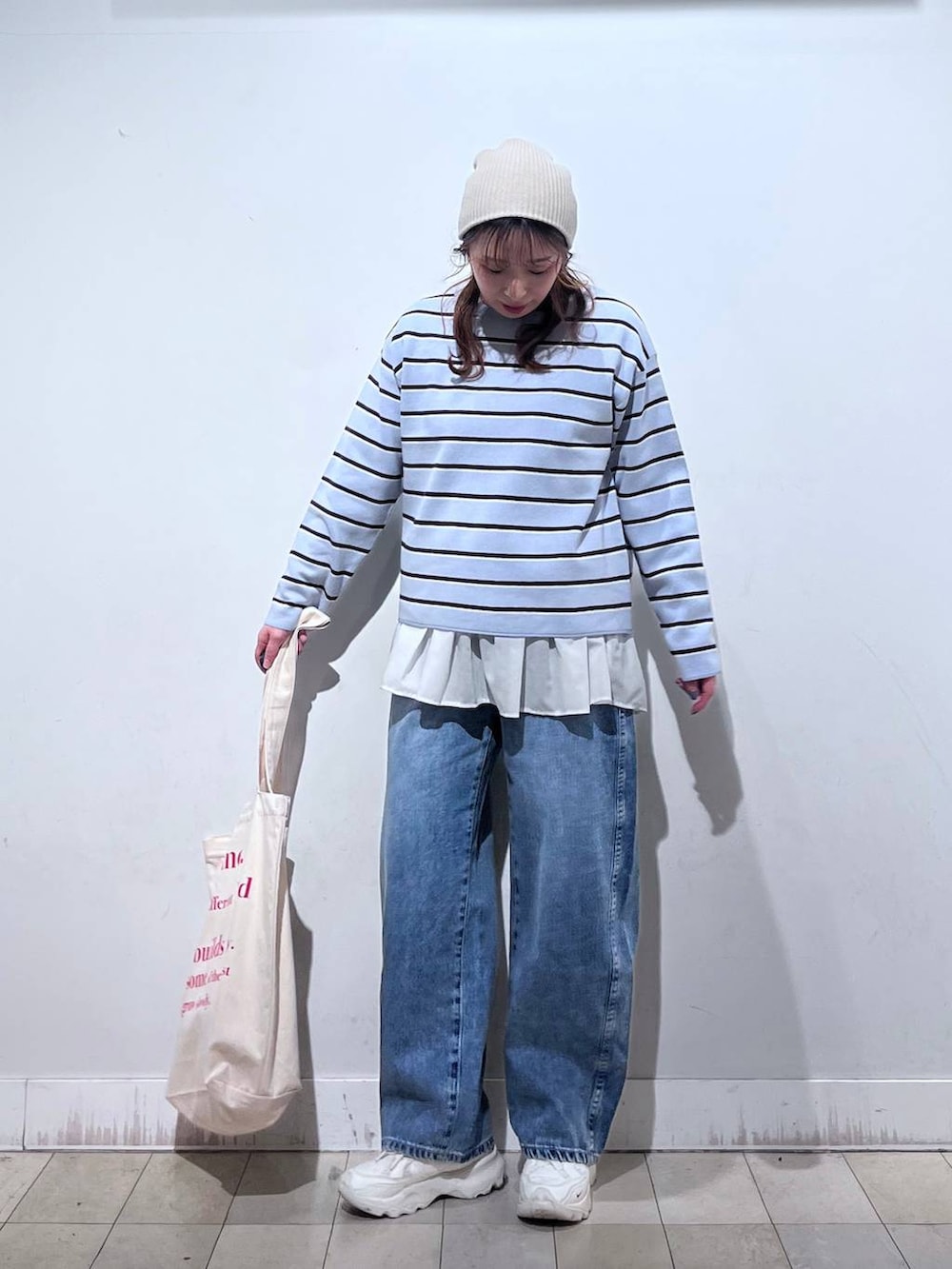 ホワイト系のTシャツ/カットソー、ホワイト系のトートバッグ、ブルー系のニット/セーターを着用したレディースの冬コーディネートの5枚目の写真