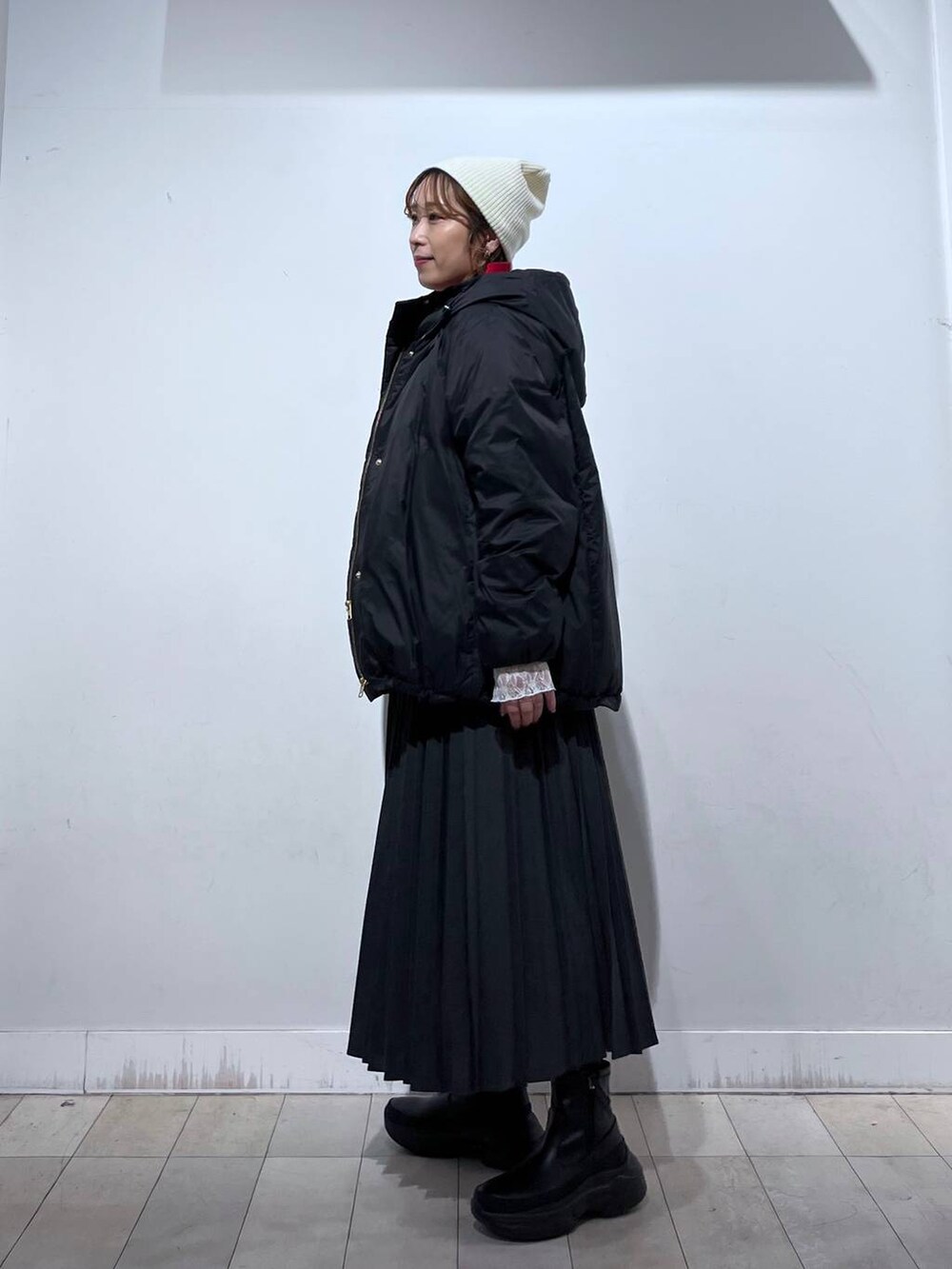 ブラック系のダウンジャケット/コート、ホワイト系のTシャツ/カットソー、レッド系のニット/セーターを着用したレディースの冬コーディネートの2枚目の写真