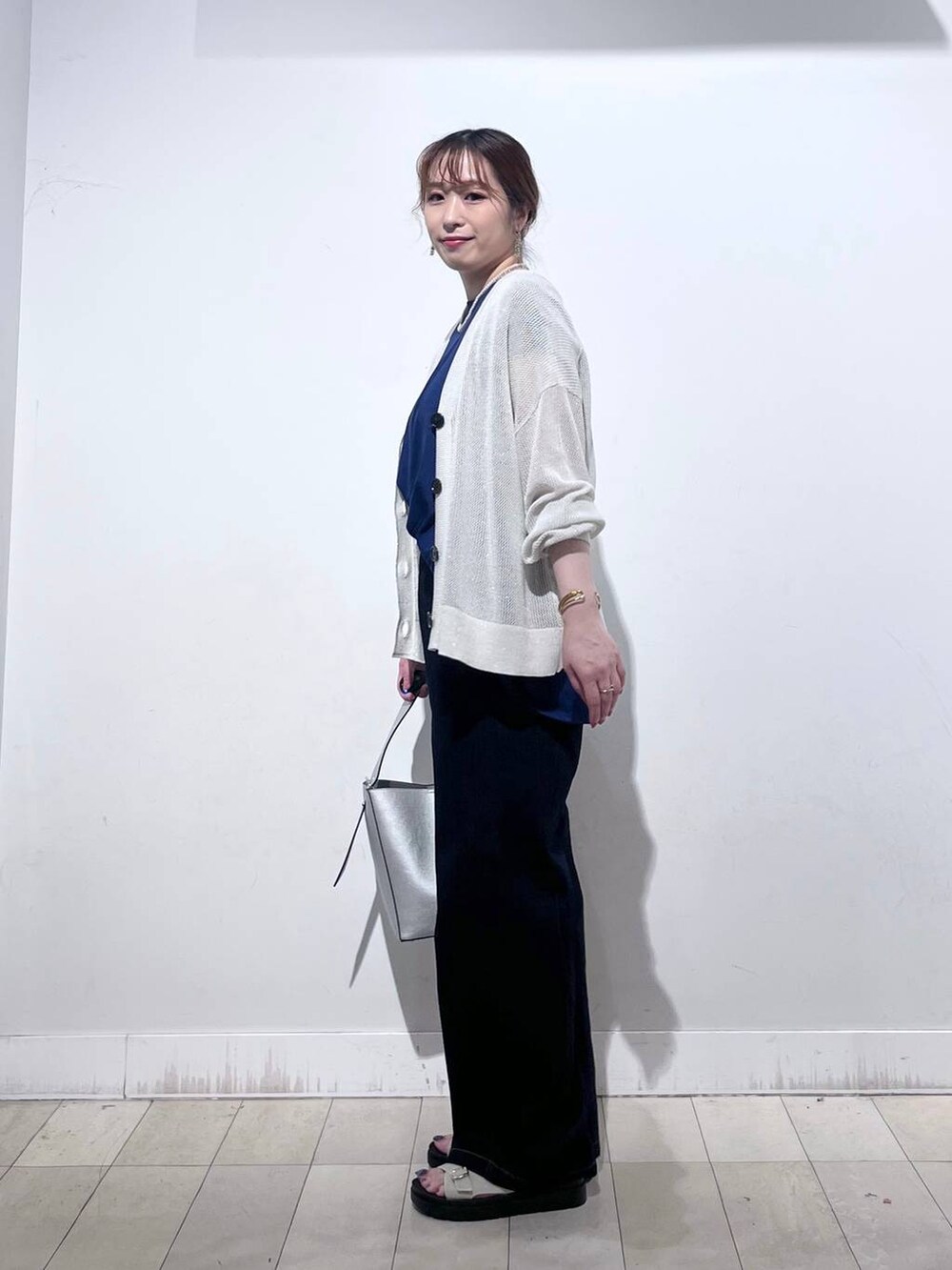 シルバー系のショルダーバッグ、ホワイト系のカーディガン/ボレロ、ホワイト系のサンダルを着用したレディースの夏コーディネートの5枚目の写真