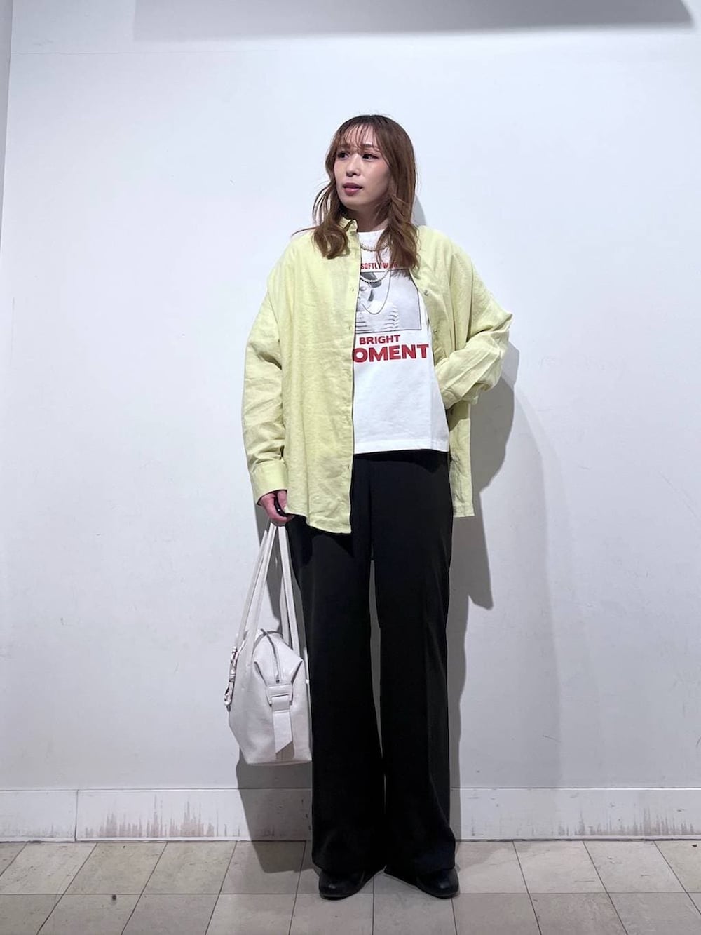 ホワイト系のボストンバッグ、ブラック系のブーツ、イエロー系のシャツ/ブラウスを着用したレディースの春コーディネートの7枚目の写真