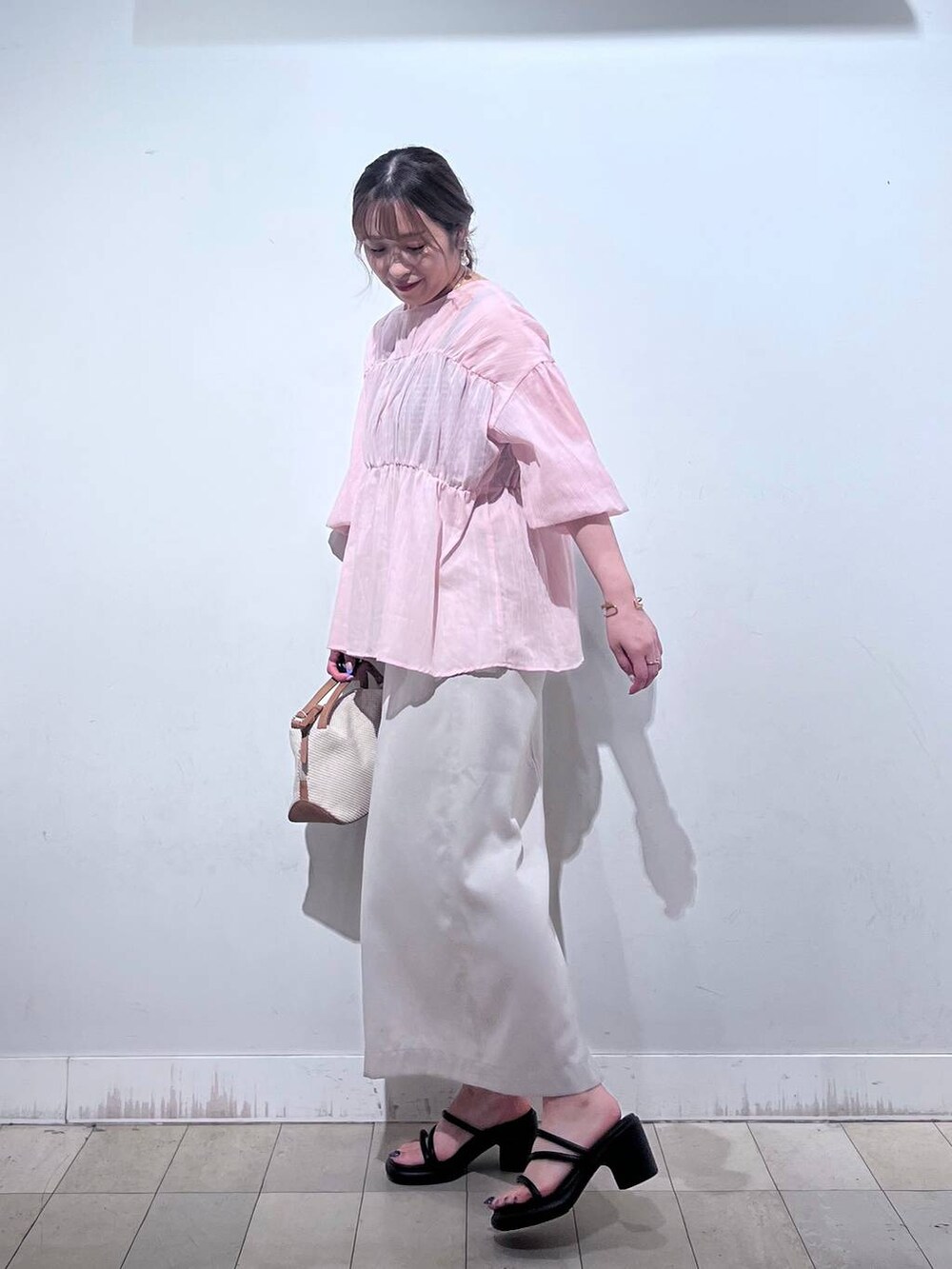 ホワイト系のショルダーバッグ、グレー系のスカートを着用したレディースの夏コーディネートの4枚目の写真