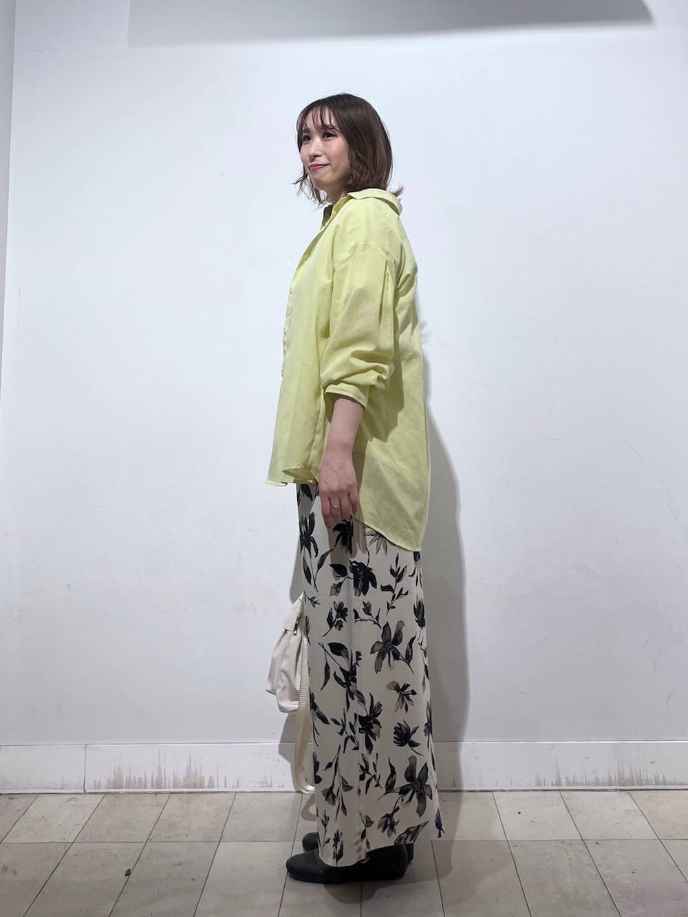 ホワイト系のショルダーバッグ、ホワイト系のTシャツ/カットソー、イエロー系のシャツ/ブラウスを着用したレディースの春コーディネートの3枚目の写真