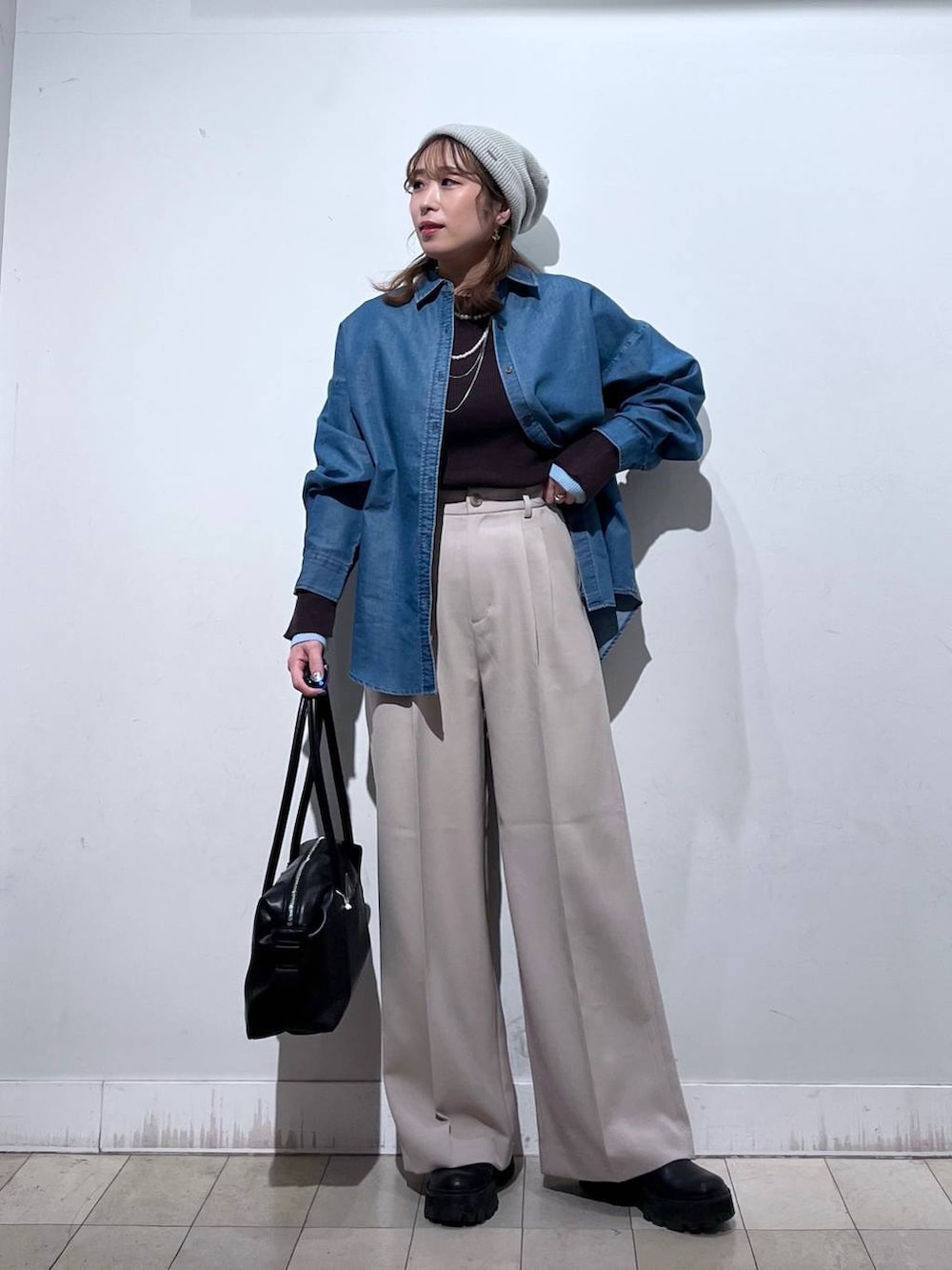 ブラック系のボストンバッグ、ブルー系のシャツ/ブラウス、ベージュ系のその他パンツを着用したレディースの冬コーディネートの2枚目の写真