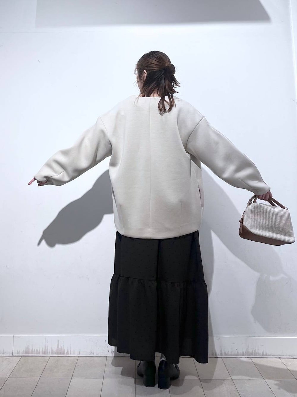ホワイト系のショルダーバッグ、ブラック系のローファー、ホワイト系のブルゾンを着用したレディースの春コーディネートの9枚目の写真