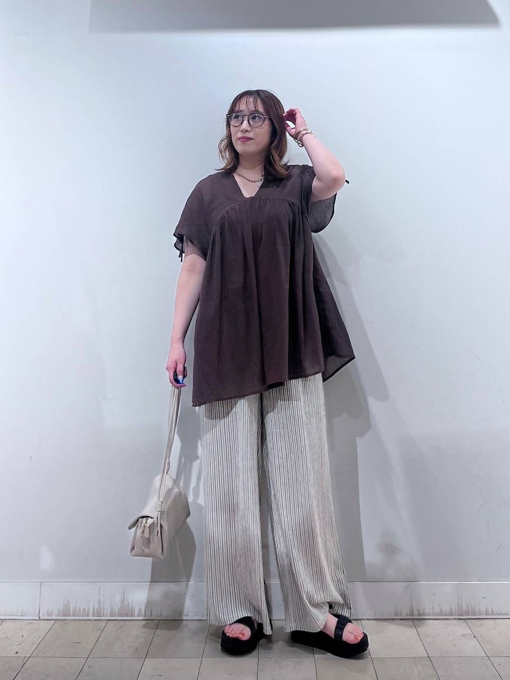 ベージュ系のショルダーバッグ、ベージュ系のその他パンツ、ブラウン系のシャツ/ブラウスを着用したレディースの夏コーディネートの4枚目の写真