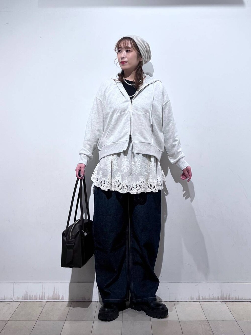 ブラウン系のボストンバッグ、ホワイト系のパーカー、ホワイト系のその他トップスを着用したレディースの冬コーディネートの7枚目の写真