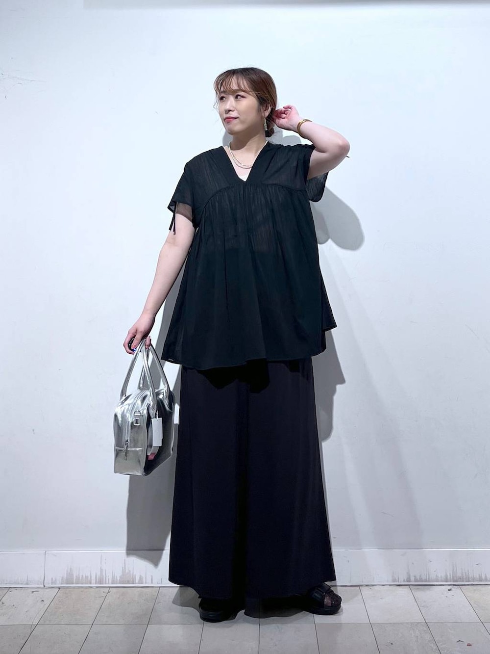 グレー系のボストンバッグ、ブラック系のサンダル、ブラック系のシャツ/ブラウスを着用したレディースの夏コーディネートの3枚目の写真