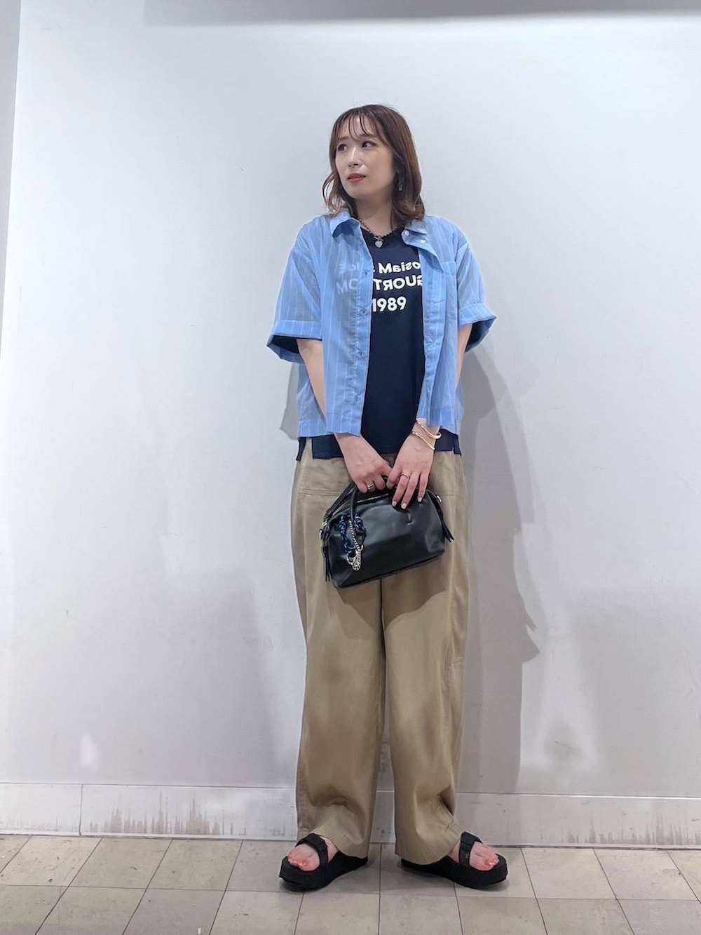 ブルー系のシャツ/ブラウス、ブルー系のTシャツ/カットソー、ブラック系のボストンバッグを着用したレディースの夏コーディネートの4枚目の写真
