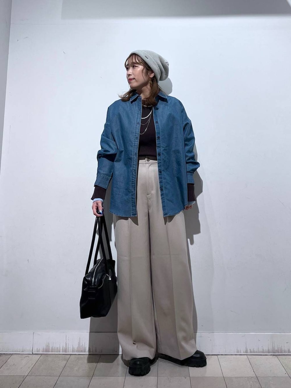 ブラック系のボストンバッグ、ブルー系のシャツ/ブラウス、ベージュ系のその他パンツを着用したレディースの冬コーディネートの7枚目の写真