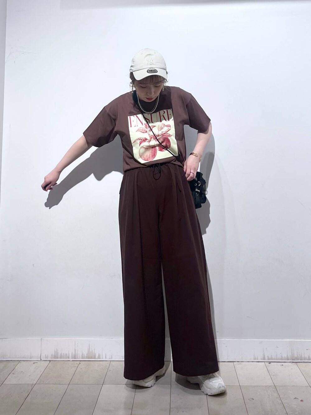 ブラウン系のTシャツ/カットソー、ホワイト系のタンクトップ、ブラック系のショルダーバッグを着用したレディースの夏コーディネートの3枚目の写真