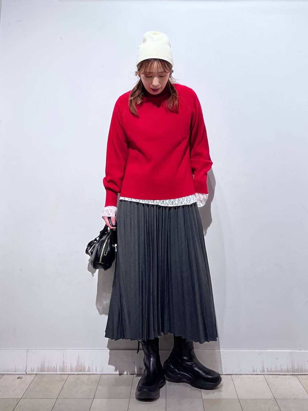 ブラック系のダウンジャケット/コート、ホワイト系のTシャツ/カットソー、レッド系のニット/セーターを着用したレディースの冬コーディネートの5枚目の写真