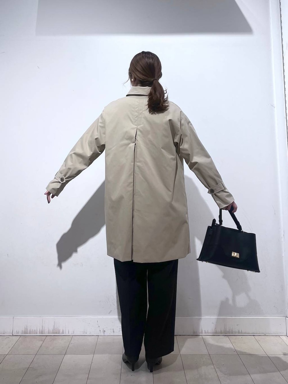 ブラック系のパンプス、ブルー系のセットアップ、ブラック系のショルダーバッグを着用したレディースの冬コーディネートの9枚目の写真