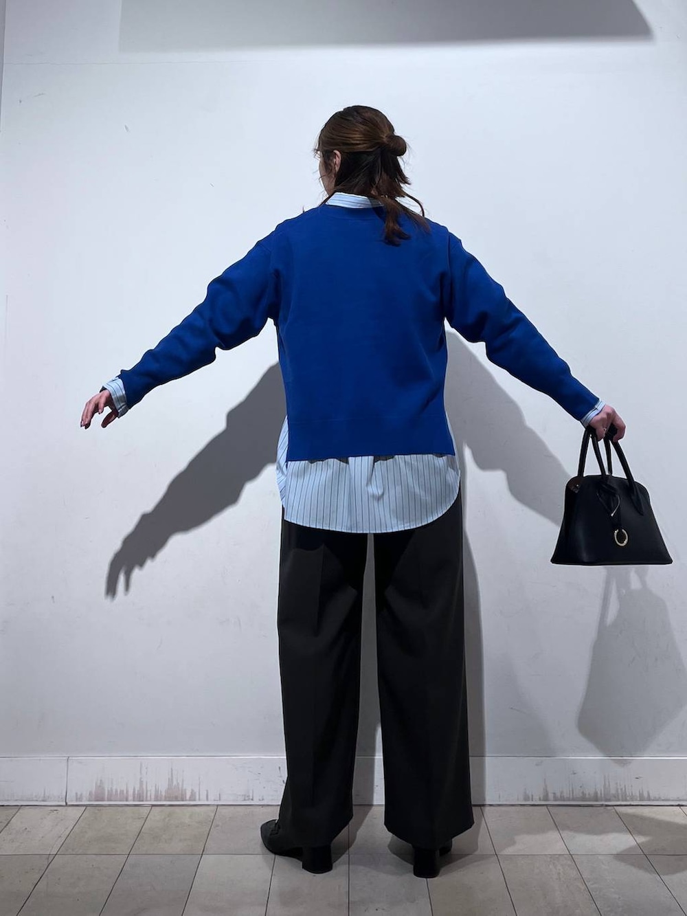 ブラック系のローファー、ブラック系のショルダーバッグ、ブルー系のシャツ/ブラウスを着用したレディースの冬コーディネートの8枚目の写真