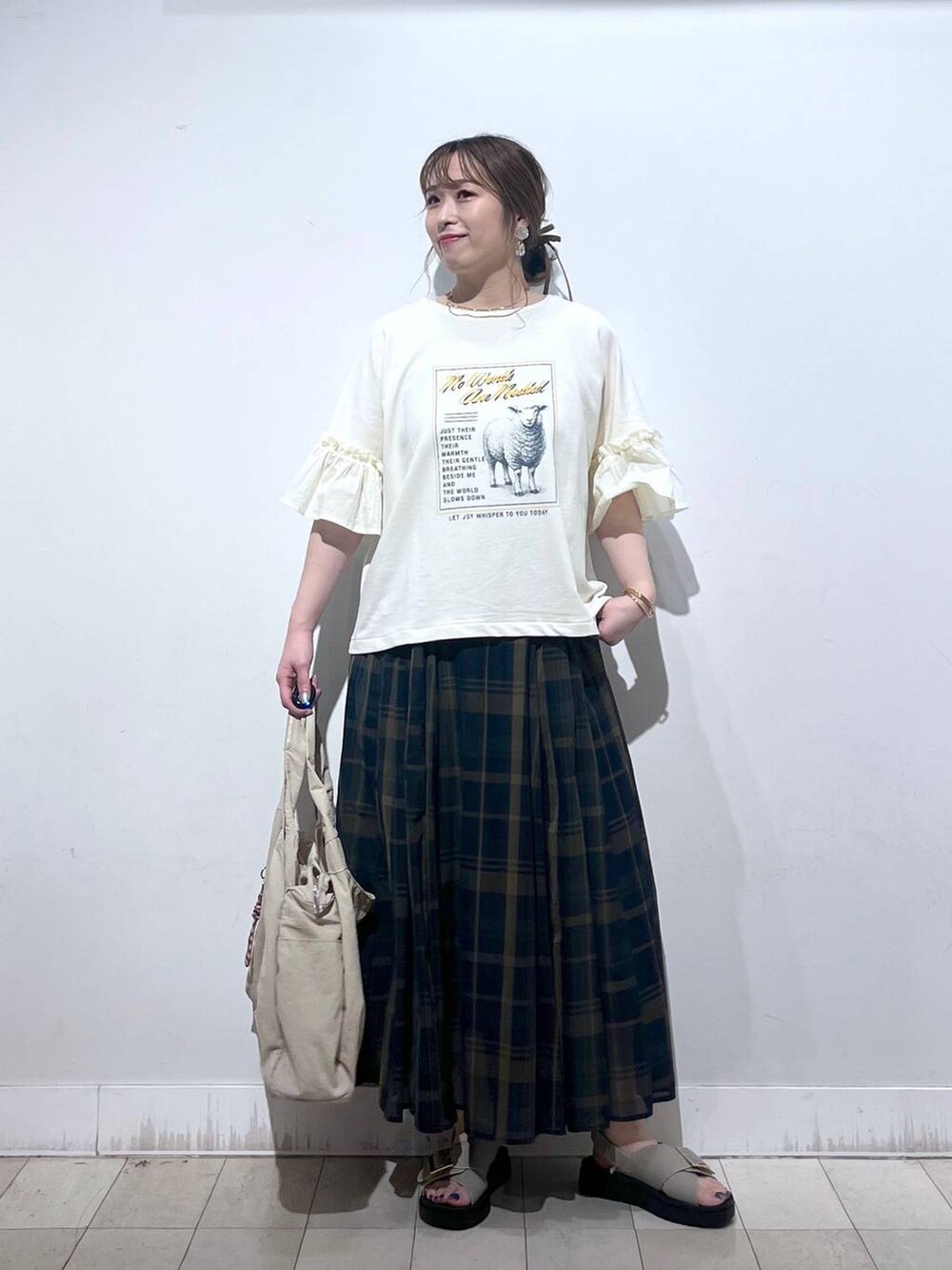 ホワイト系のタンクトップ、ベージュ系のトートバッグ、ベージュ系のサンダルを着用したレディースの秋コーディネートの9枚目の写真