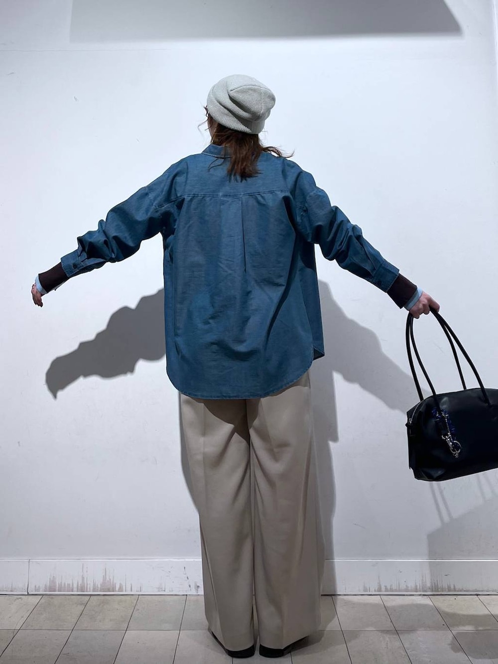 ブラック系のボストンバッグ、ブルー系のシャツ/ブラウス、ベージュ系のその他パンツを着用したレディースの冬コーディネートの4枚目の写真