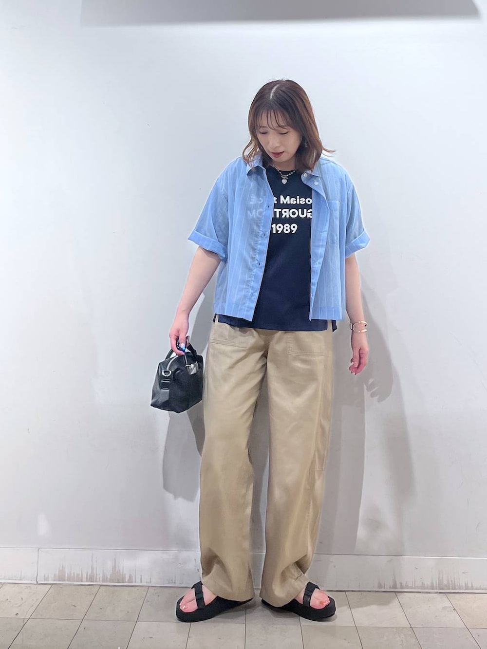 ブルー系のシャツ/ブラウス、ブルー系のTシャツ/カットソー、ブラック系のボストンバッグを着用したレディースの夏コーディネートの3枚目の写真