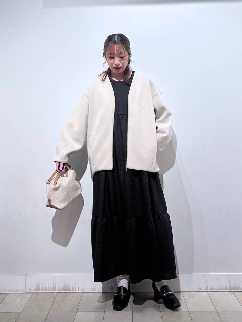 ホワイト系のショルダーバッグ、ブラック系のローファー、ホワイト系のブルゾンを着用したレディースの春コーディネートの7枚目の写真