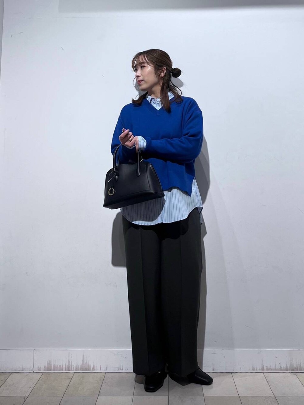ブラック系のローファー、ブラック系のショルダーバッグ、ブルー系のシャツ/ブラウスを着用したレディースの冬コーディネートの8枚目の写真