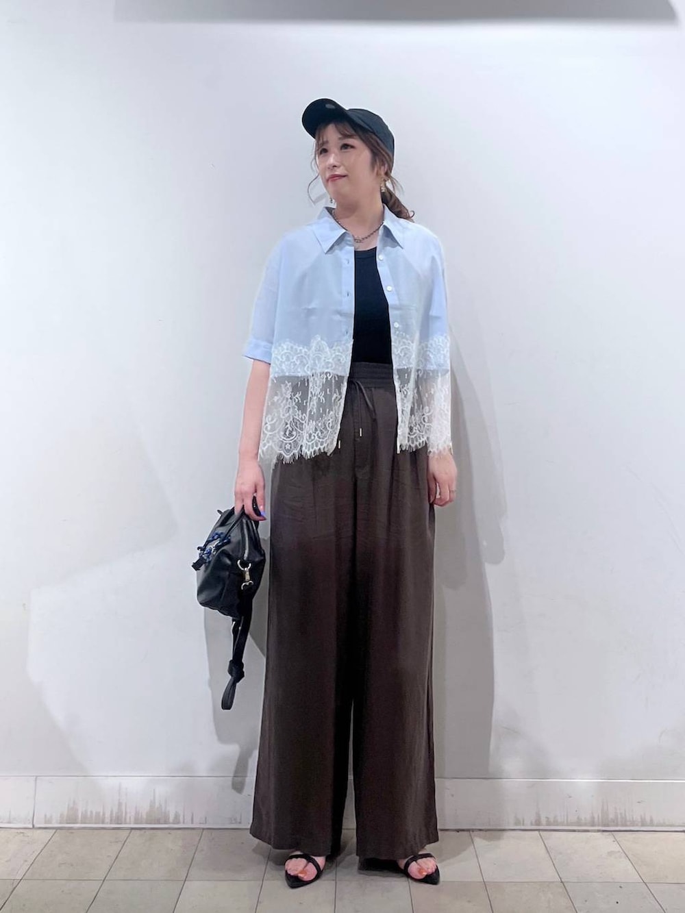 ブラウン系のその他パンツ、ブラック系のボストンバッグ、ブラック系のサンダルを着用したレディースの夏コーディネートの6枚目の写真