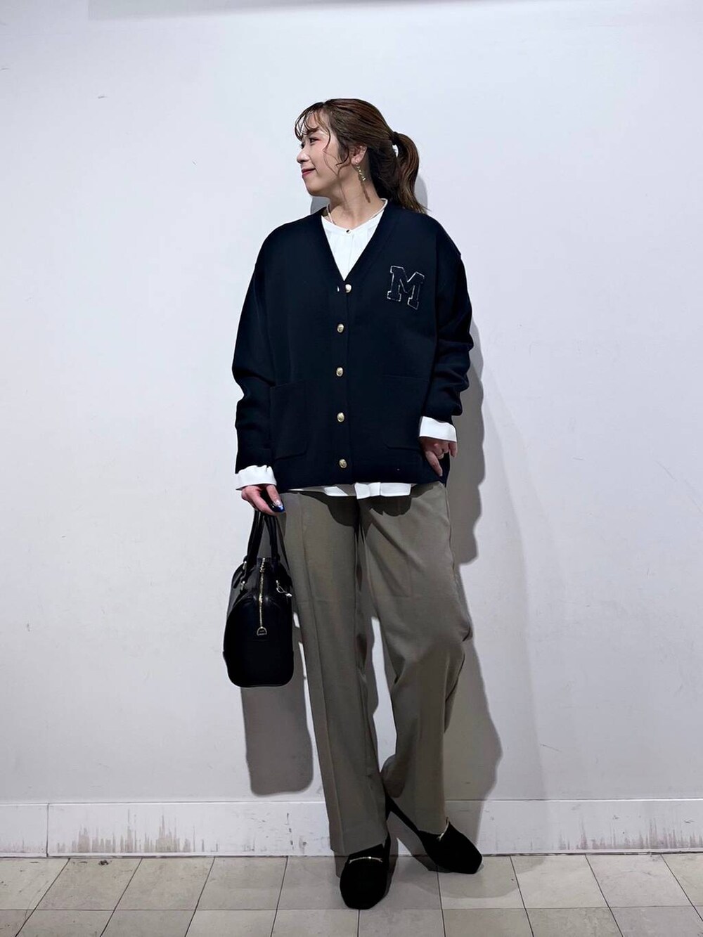 ブラック系のローファー、ベージュ系のその他パンツ、ブルー系のカーディガン/ボレロを着用したレディースの秋コーディネートの5枚目の写真