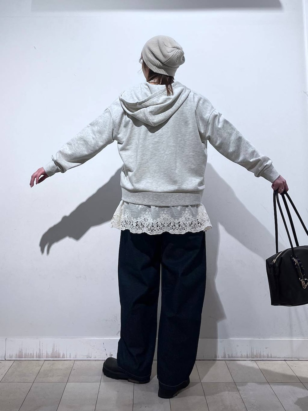 ブラウン系のボストンバッグ、ホワイト系のパーカー、ホワイト系のその他トップスを着用したレディースの冬コーディネートの6枚目の写真