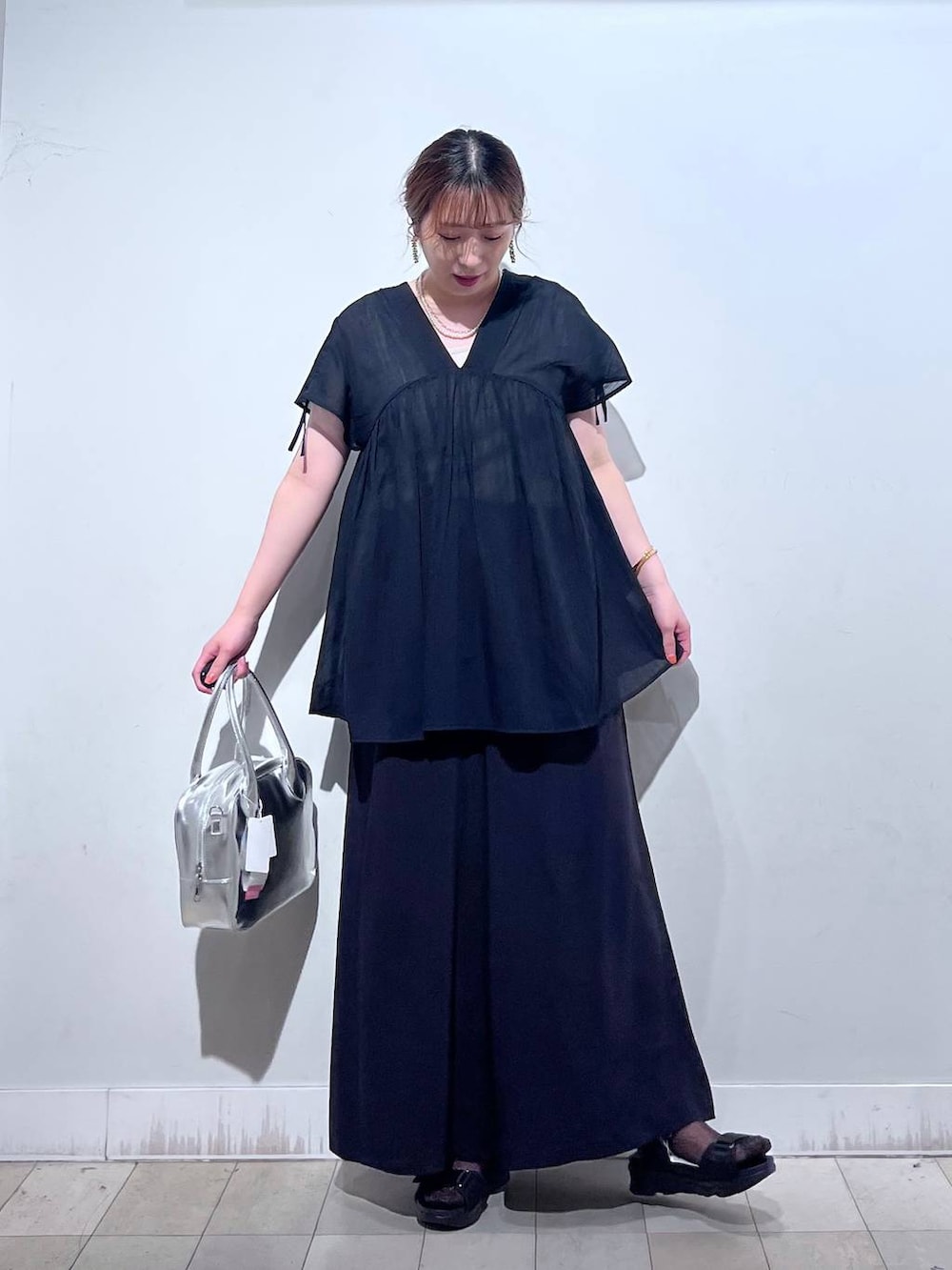 グレー系のボストンバッグ、ブラック系のサンダル、ブラック系のシャツ/ブラウスを着用したレディースの夏コーディネートの4枚目の写真