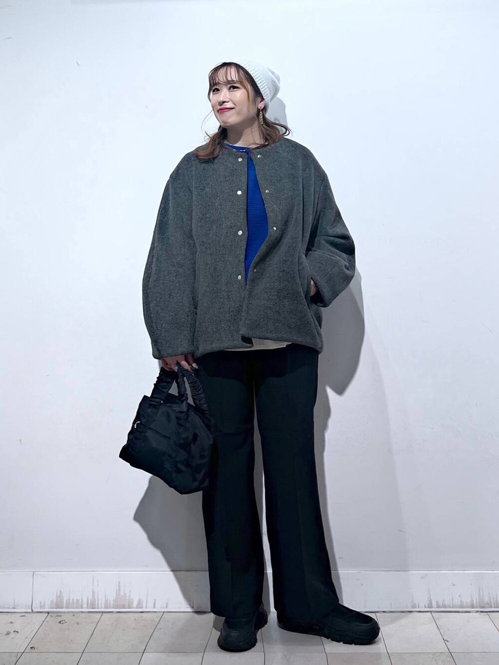 ブラック系のスニーカー、ブラック系のショルダーバッグ、グレー系のノーカラーコートを着用したレディースの秋コーディネートの8枚目の写真