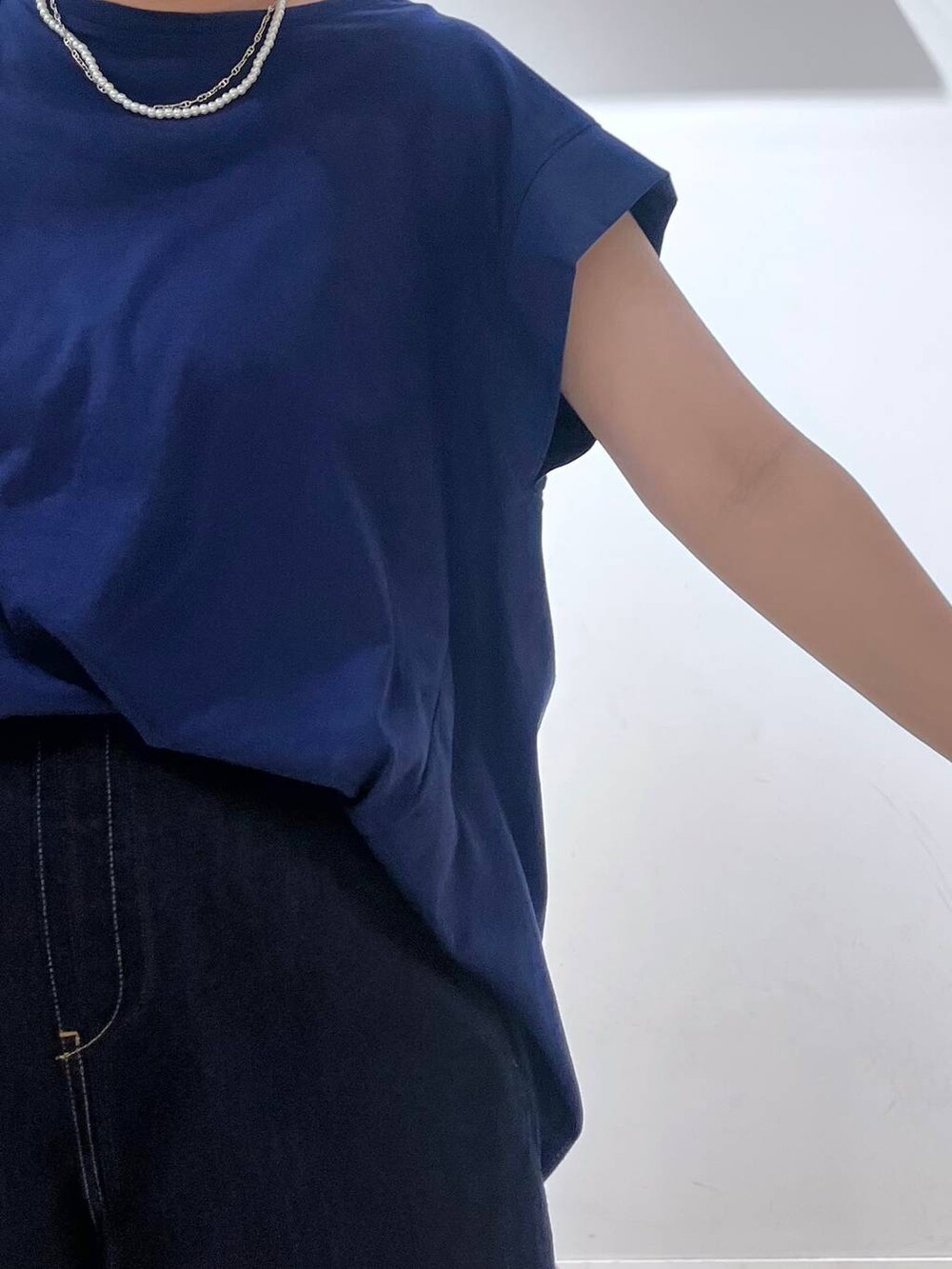 シルバー系のショルダーバッグ、ホワイト系のカーディガン/ボレロ、ホワイト系のサンダルを着用したレディースの夏コーディネートの2枚目の写真