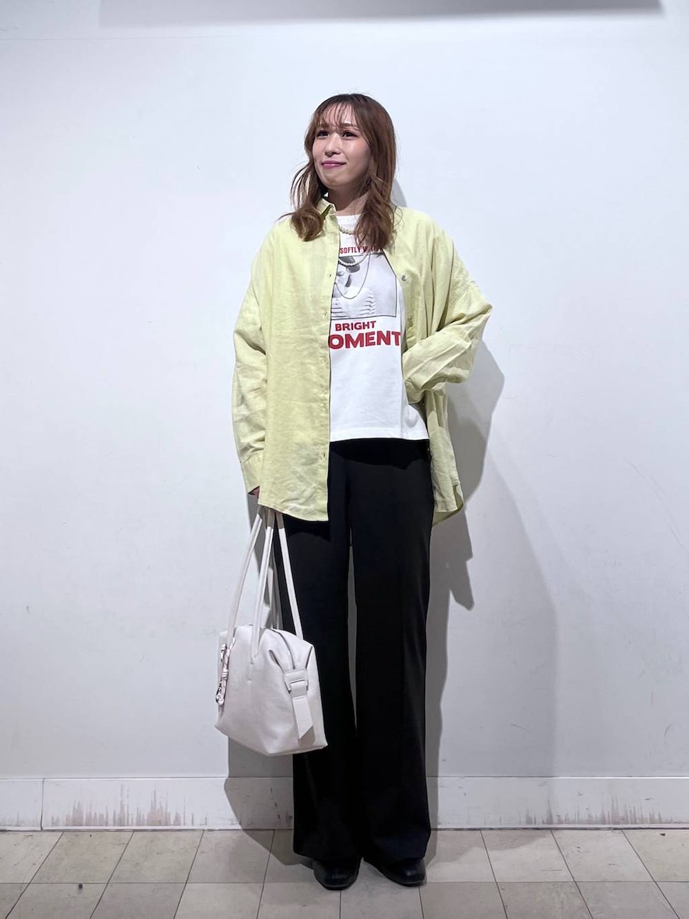 ホワイト系のボストンバッグ、ブラック系のブーツ、イエロー系のシャツ/ブラウスを着用したレディースの春コーディネートの8枚目の写真
